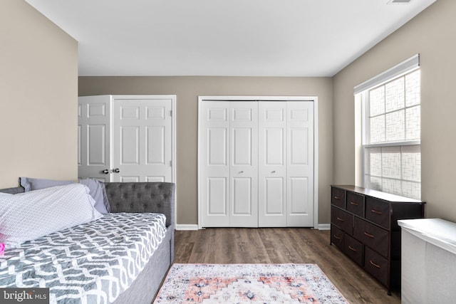 bedroom featuring visible vents, dark wood-style floors, and baseboards