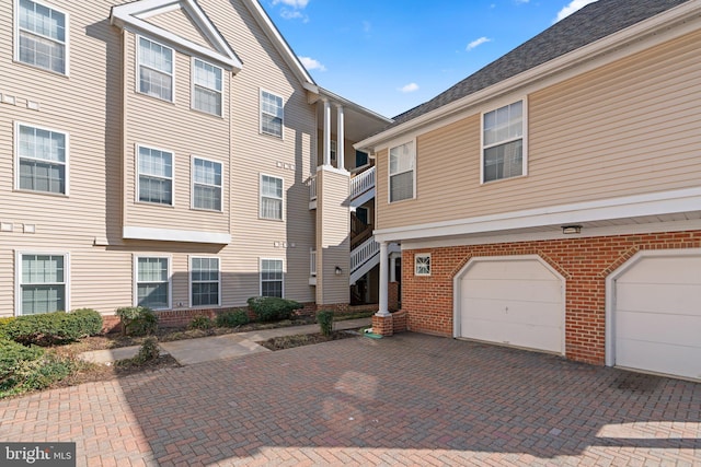 exterior space featuring decorative driveway and an attached garage