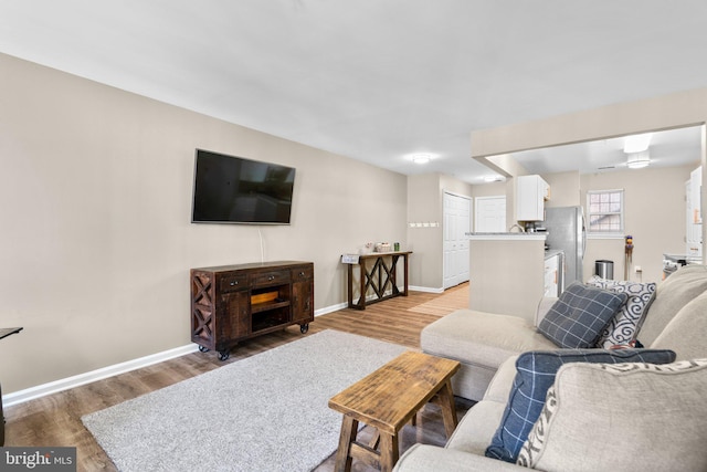 living area with baseboards and light wood finished floors