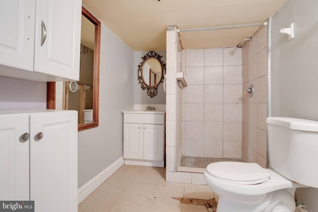 full bathroom with toilet, a stall shower, baseboards, and vanity