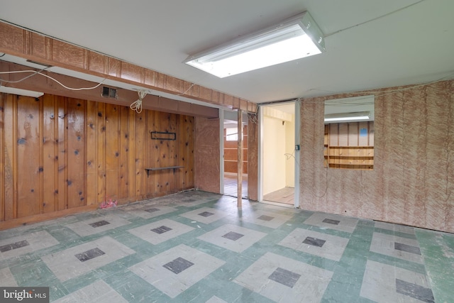 finished below grade area with wooden walls and tile patterned floors