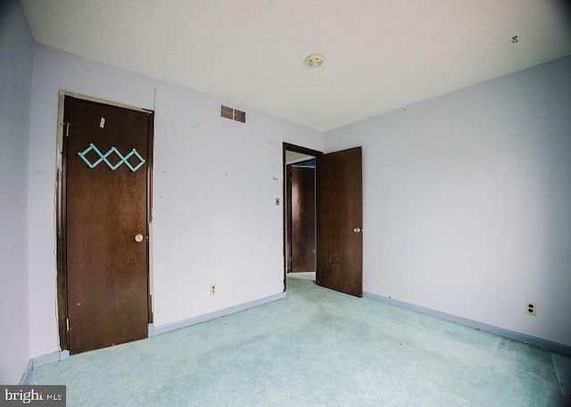 unfurnished bedroom with light colored carpet, visible vents, and baseboards