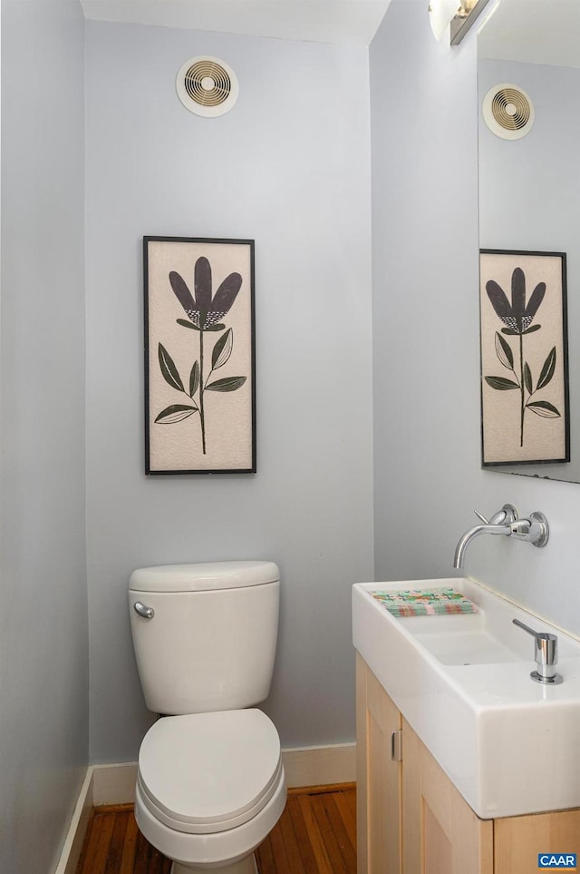 bathroom with wood finished floors, visible vents, and baseboards