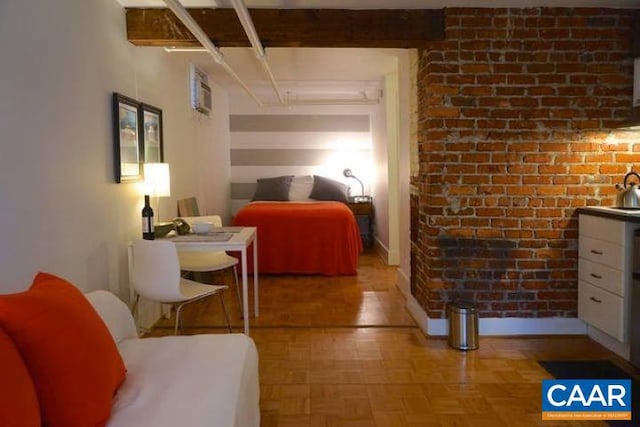 bedroom featuring baseboards and brick wall