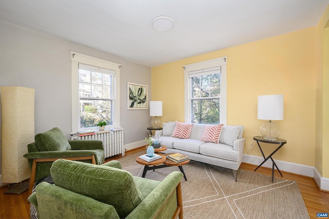 living room featuring radiator, baseboards, and wood finished floors