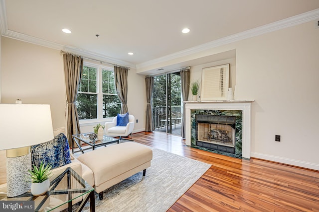 living area featuring crown molding, baseboards, and wood finished floors