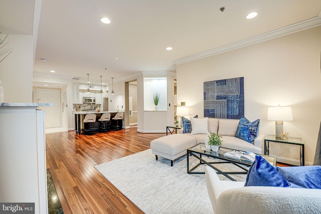 living room featuring crown molding, recessed lighting, and light wood-style floors