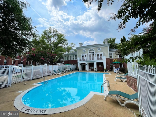 community pool featuring a patio area and fence