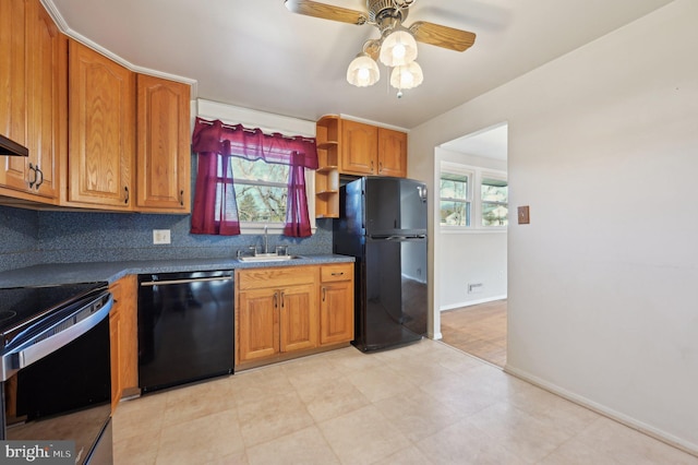 kitchen featuring brown cabinetry, backsplash, black appliances, and a sink