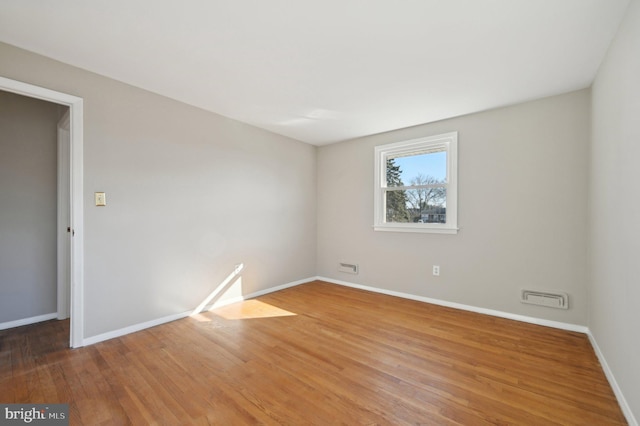 empty room with light wood-style flooring and baseboards