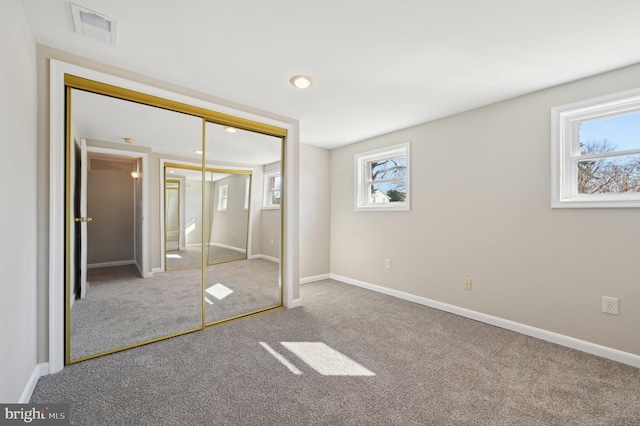 unfurnished bedroom featuring visible vents, baseboards, carpet, and a closet