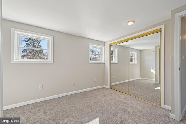 unfurnished bedroom with carpet flooring, baseboards, and a closet