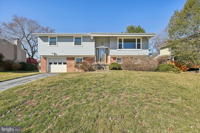 bi-level home with brick siding, driveway, an attached garage, and a front lawn