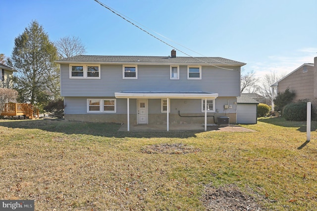 view of front of home featuring a wooden deck, central AC, a chimney, a front lawn, and a patio area