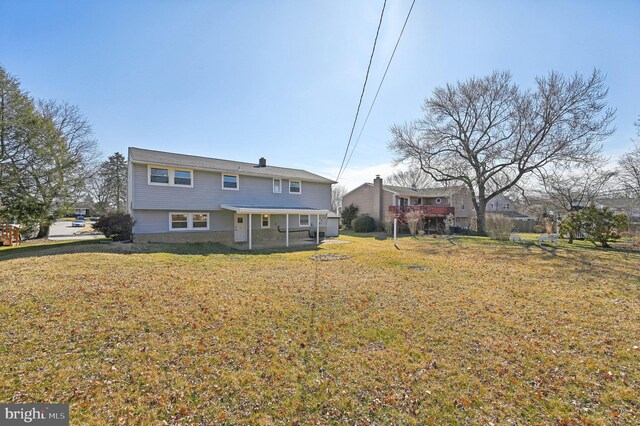 rear view of property featuring a yard