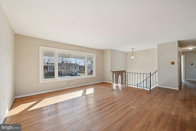 unfurnished room featuring baseboards and wood-type flooring