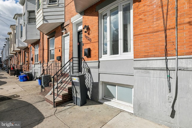 doorway to property featuring a residential view and brick siding