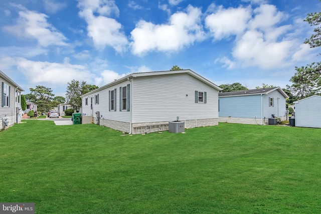 view of side of property with a yard and cooling unit