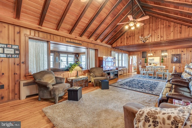 living room with wood ceiling, radiator heating unit, light wood-style flooring, and wooden walls