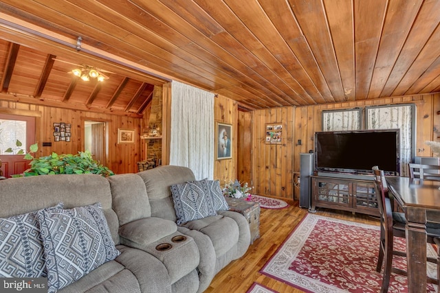 living area with lofted ceiling, wooden ceiling, wooden walls, and wood finished floors