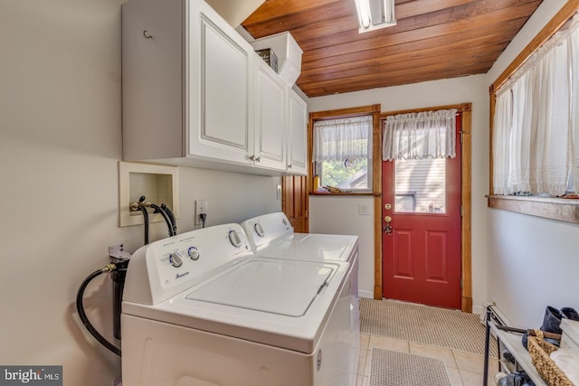 clothes washing area with wood ceiling, light tile patterned flooring, cabinet space, and washer and dryer