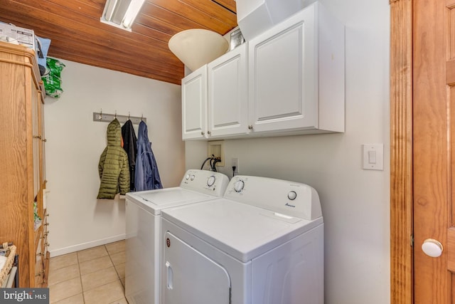 laundry area with washer and clothes dryer, light tile patterned floors, cabinet space, wooden ceiling, and baseboards