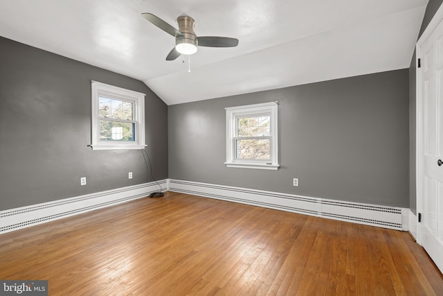 interior space with a wealth of natural light, a baseboard radiator, and hardwood / wood-style floors