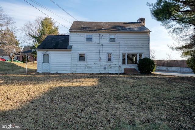 rear view of property with a yard and a chimney