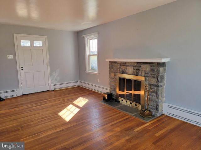 unfurnished living room with a stone fireplace, baseboard heating, and wood finished floors