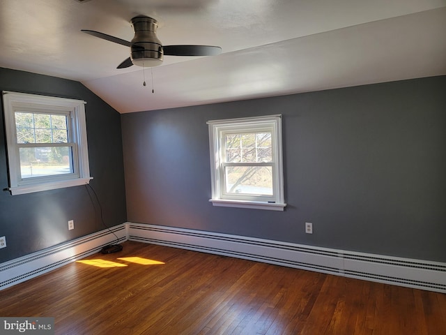 spare room with vaulted ceiling, hardwood / wood-style floors, baseboard heating, and a ceiling fan