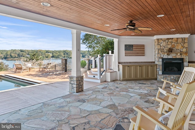 803 Coachway, Annapolis, MD 21401 - view of patio / terrace with a water view, an outdoor stone fireplace, and a ceiling fan