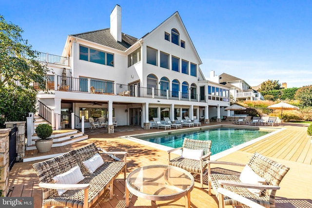 803 Coachway, Annapolis, MD 21401 - back of property with stucco siding, a chimney, a balcony, an outdoor pool, and a patio