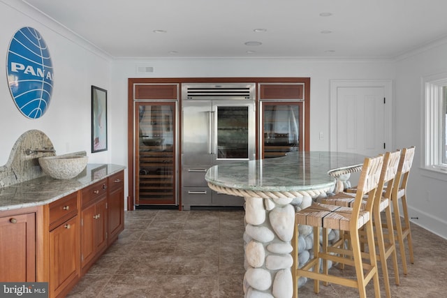 803 Coachway, Annapolis, MD 21401 - kitchen with a breakfast bar, ornamental molding, light stone countertops, and stainless steel built in refrigerator