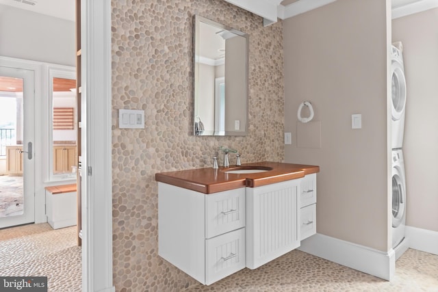 803 Coachway, Annapolis, MD 21401 - bathroom featuring visible vents, baseboards, stacked washer and clothes dryer, and vanity