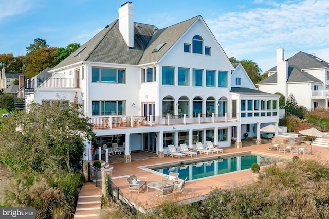 803 Coachway, Annapolis, MD 21401 - back of property with stucco siding, a chimney, a balcony, an outdoor pool, and a patio