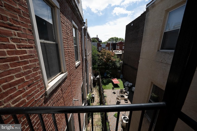 view of home's exterior featuring brick siding and a balcony