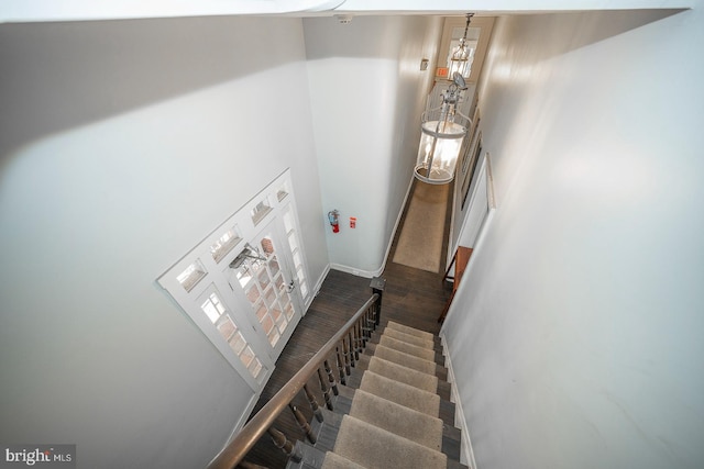 stairs with a towering ceiling, baseboards, and wood finished floors