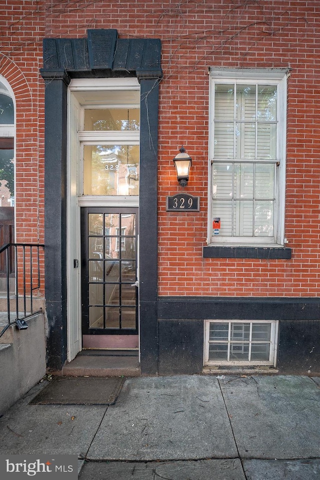 doorway to property featuring brick siding