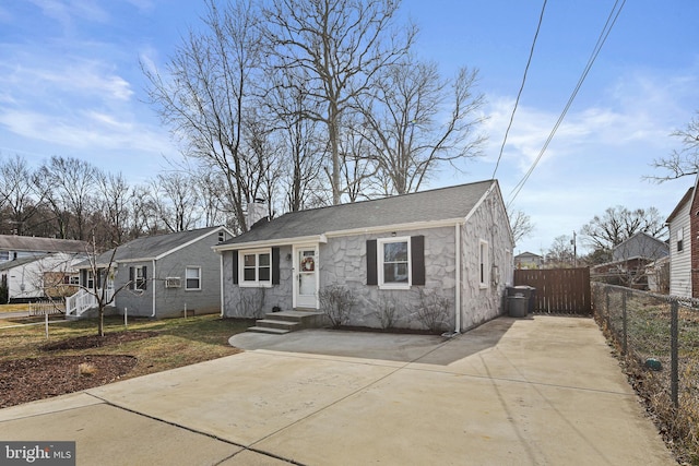 bungalow featuring a shingled roof, fence, and a chimney