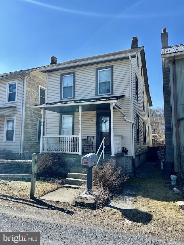 view of front of home with a porch and a chimney