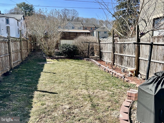 view of yard featuring a fenced backyard and a residential view