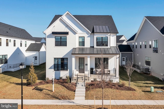 modern farmhouse with a standing seam roof, board and batten siding, covered porch, and metal roof