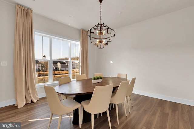 dining area with wood finished floors, baseboards, and a chandelier