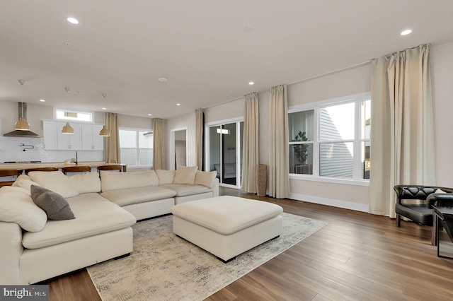 living room featuring recessed lighting, baseboards, and wood finished floors