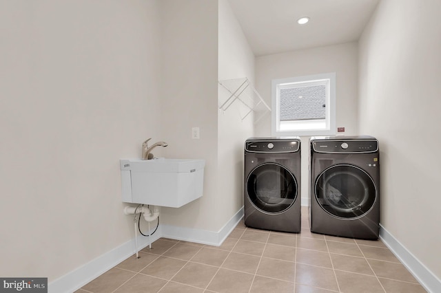 laundry room with light tile patterned floors, laundry area, washer and dryer, and baseboards