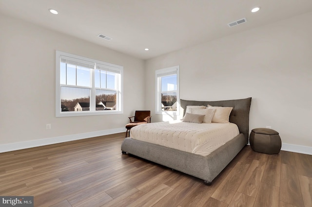 bedroom featuring recessed lighting, visible vents, baseboards, and wood finished floors