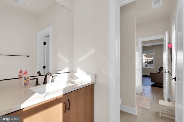 bathroom featuring tile patterned floors, visible vents, baseboards, and vanity