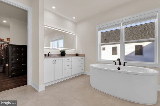 full bathroom with vanity, baseboards, a soaking tub, recessed lighting, and tile patterned flooring