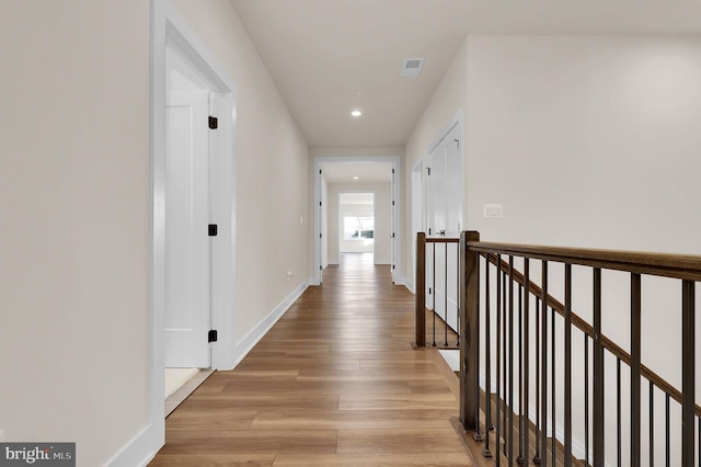 corridor with visible vents, recessed lighting, baseboards, and light wood-type flooring