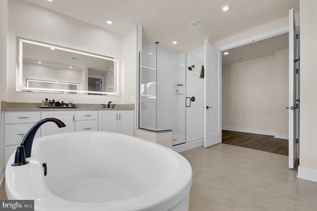 bathroom featuring recessed lighting, visible vents, a shower stall, and a freestanding tub